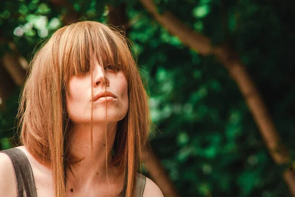 Yüzündeki altın saçlı kız ormanın kokusu inhales