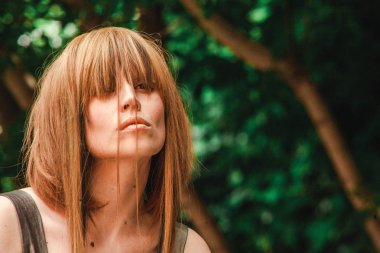 Yüzündeki altın saçlı kız ormanın kokusu inhales