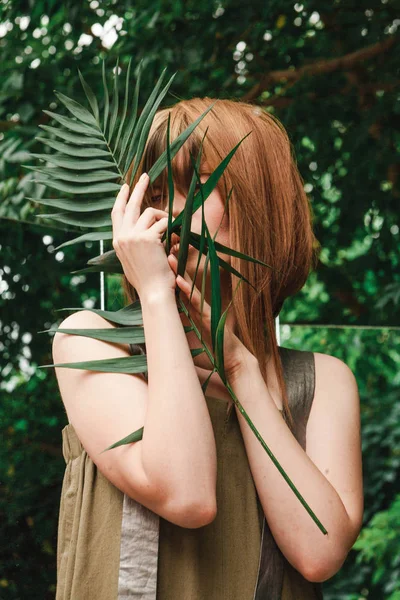 Kız fern şube onun elinde sıkar.
