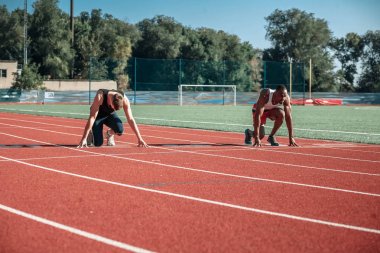 Başında iki erkekle stadyumda kırmızı koşu bandı