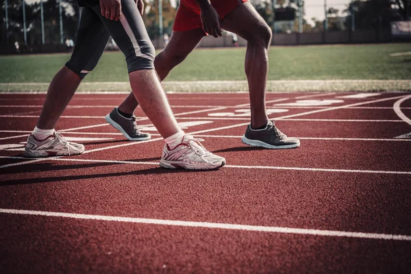 As pernas de um atleta masculino branco e preto — Fotografia de Stock
