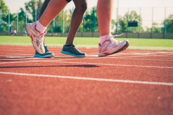 Бегущие ноги белых и черных спортсменов — стоковое фото