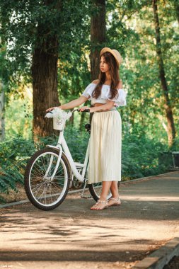 Bir kız adımları bir bisiklet ile bir cadde üzerinde