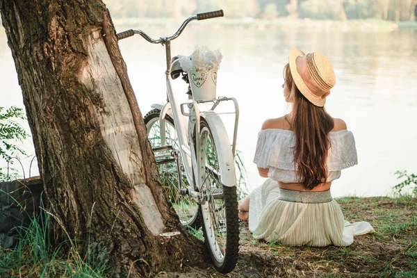 Menina romântica com uma bicicleta na margem do rio — Fotografia de Stock