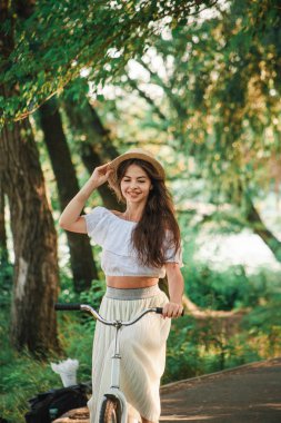 Bir kız direksiyonuna bir ele sahip bir bisiklet ile gidiyor