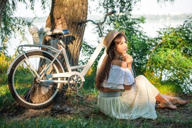 Nehrin yanında bir ağacın altında oturan romantik kız