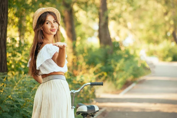 Zarif bir şapkalı bir kız bir hava öpücük gönderir