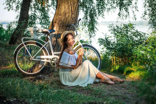 Emotional happy girl sitting next to a bicycle — Stock Photo, Image