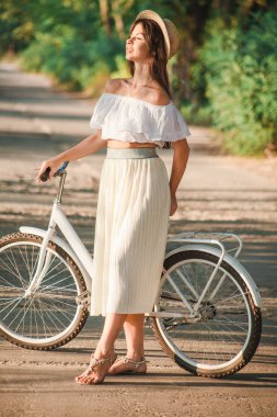 Bir kız yüzünü güneşe koyar.