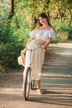 Bir kız bir bisiklet üzerinde oturan ve gülümseyen