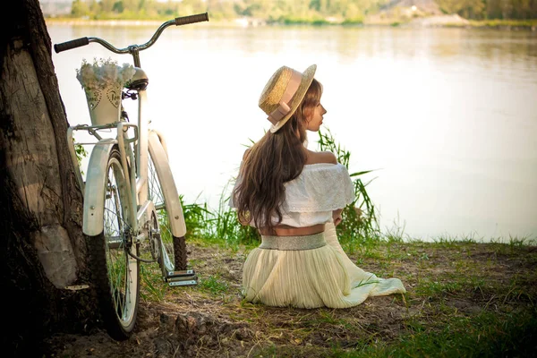 Menina de bicicleta branca e branca no fundo do rio — Fotografia de Stock