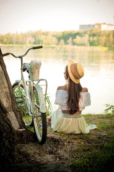 Menina romântica sentada sob uma árvore junto ao lago — Fotografia de Stock