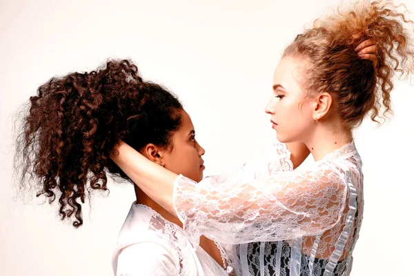 Две девушки тянут друг друга за волосы. Афро-блондинка — стоковое фото