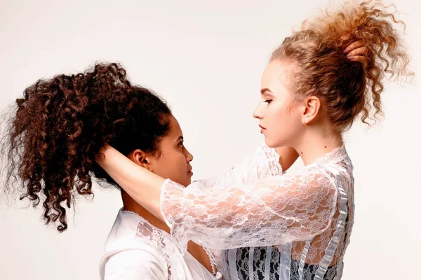 Две девушки тянут друг друга за волосы. Афро-блондинка — стоковое фото