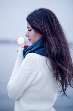 Kadın beyaz bir kazak ve örme atkı