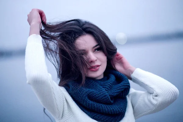 Женщина в белом свитере и вязаном шарфе — стоковое фото