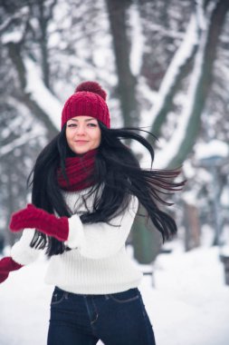 Bir kız kot ve beyaz bir kazak kar üzerinden çalışır