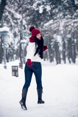 Bir kız kot ve beyaz bir kazak kar üzerinden çalışır