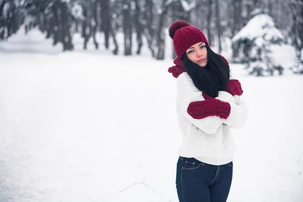 Una giovane donna dolce, tenera e sensuale con un maglione bianco e un cappello luminoso, sciarpa e guanti — Foto Stock