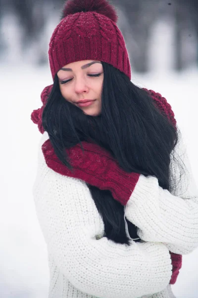 一个甜美, 温柔和感性的年轻女子穿着白色毛衣和明亮的帽子, 围巾和手套 — 图库照片