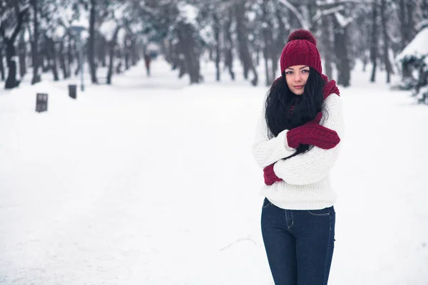 Una giovane donna dolce, tenera e sensuale con un maglione bianco e un cappello luminoso, sciarpa e guanti — Foto Stock