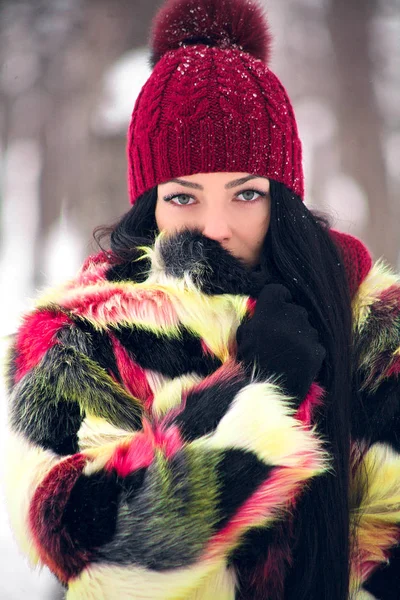 Beautiful girl wrapped in a colorful coat — Stock Photo, Image
