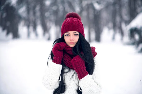 Una giovane donna dolce, tenera e sensuale con un maglione bianco e un cappello luminoso, sciarpa e guanti — Foto Stock