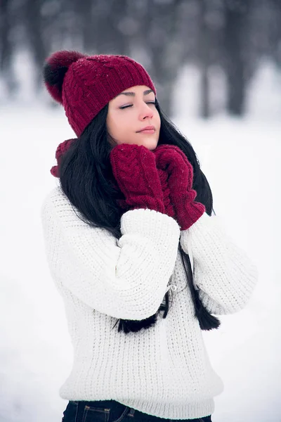 Een lief, teder en sensuele jonge vrouw in een witte trui en een heldere muts, sjaal en wanten Rechtenvrije Stockfoto's