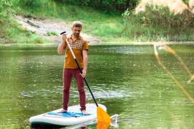 Bir yandan çarklı bir sup tahta üzerinde olan bir adam