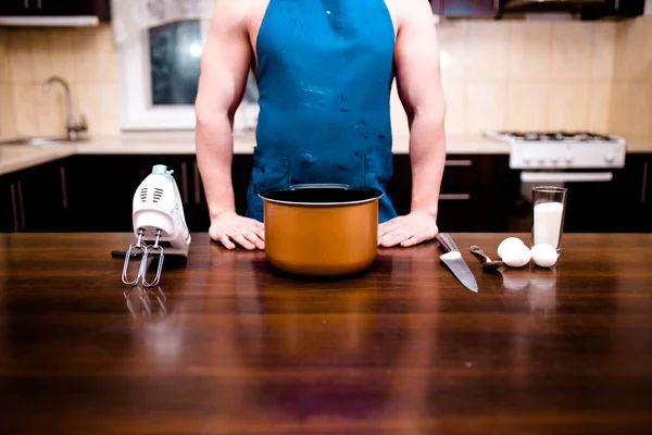 Um jovem está cozinhando numa grande cozinha — Fotografia de Stock