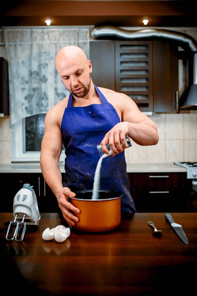 A young man is cooking in a large kitchen — Stock Photo, Image