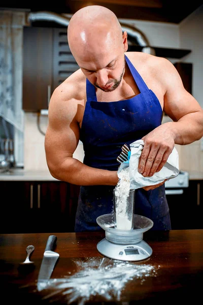 A young man is cooking in a large kitchen