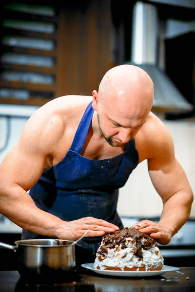 A young man is cooking in a large kitchen