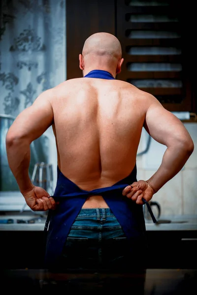 A young man chefs takes off his apron — Stock Photo, Image