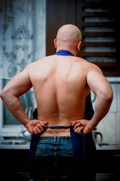 A young man chefs takes off his apron — Stock Photo, Image