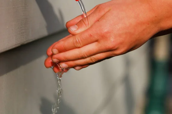 Wash hands, a man washes his hands under the tap with soap and water. A man rinsing his hands under flowing water