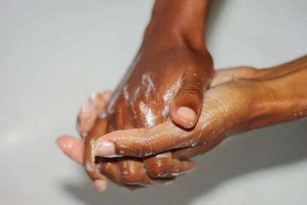 Wash hands, a man washes his hands under the tap with soap and water. A man rinsing his hands under flowing water