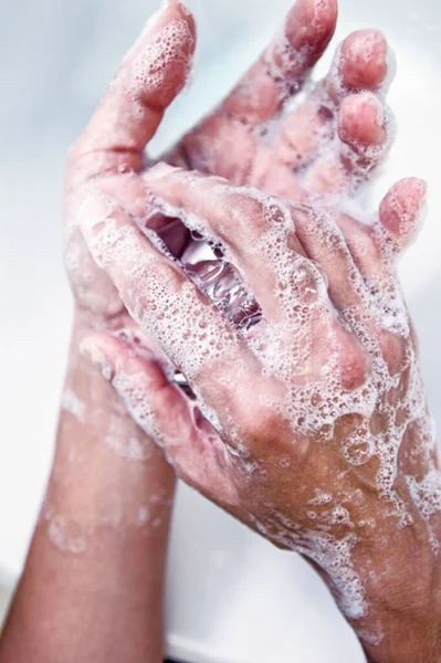 Wash hands, a man washes his hands under the tap with soap and water. A man rinsing his hands under flowing water