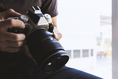 Profesyonel fotoğrafçı odaklan ve fotoğrafçılık tutkusuna arka planda yumuşak bir odak ile devam et. ışık ve film tonunda