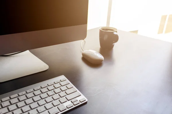 Desktopcomputer op zwarte houten tafel in kantoor — Stockfoto