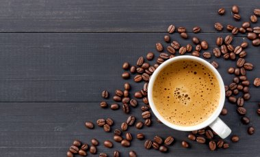 Tahta arka planda sıcak kahve ve fasulye. en üstteki görünüm