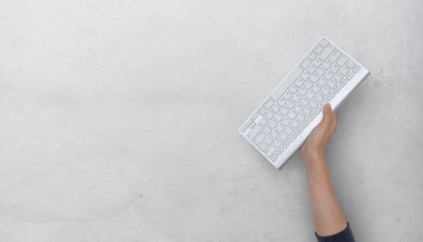 İş, sıkı çalışma konsepti. Beyaz arkaplan üzerinde el ele tutuşan klavye bilgisayarı