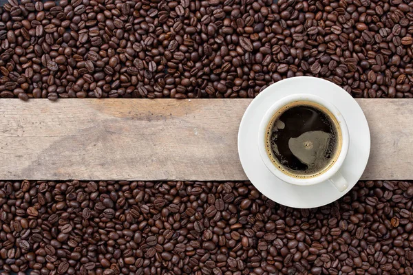 Heißer Kaffee Und Bohnen Auf Holzuntergrund Ansicht Von Oben — Stockfoto