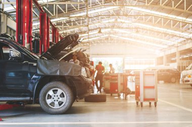 Arkaplanda hafif odaklı ve ışığın üstünde çalışan tamirci araba bakımı