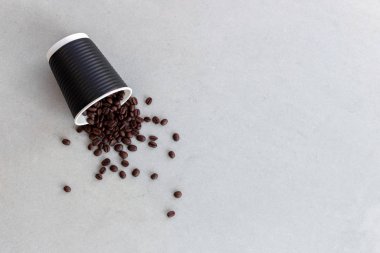 Beton zeminde kağıt bardak ve kahve çekirdekleri.