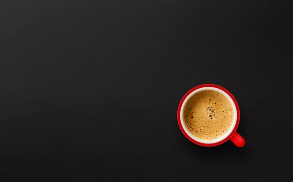 Czerwona filiżanka kawy na czarnym papierze tle. widok z góry — Zdjęcie stockowe