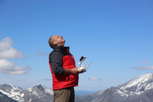 Piloot controleert de drone die vlucht uitvoert over de bergen — Stockfoto