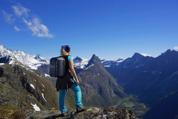 Tourist girl hikes the Romsdalseggen ridge