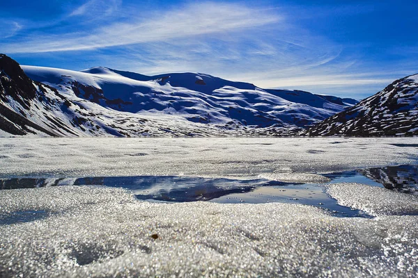 Güzel bulutlu fiyort manzarası ve önünde taşlar olan bir yol. Norveç.