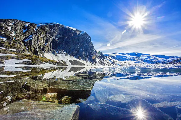 Güzel bulutlu fiyort manzarası ve önünde taşlar olan bir yol. Norveç.